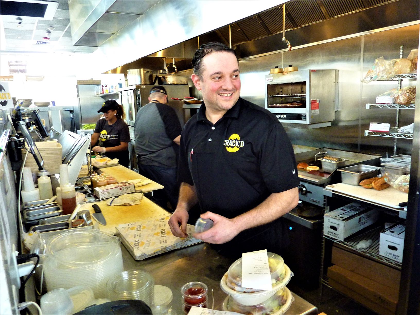 CRACK'D co-founder Danny Azzarello works the kitchen at his restaurant in Andover, Mass.