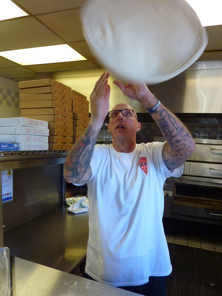 Ken Martin spins a pizza at his restaurant, Carmella's in Middletown, R.I.